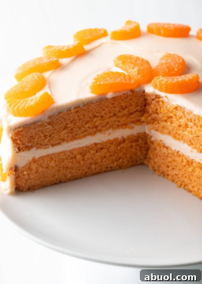 Showing inside of cake, with slices removed. Two layers of orange crush cake with orange frosting between.