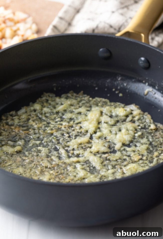 Garlic being sautéed in a pan with butter. 