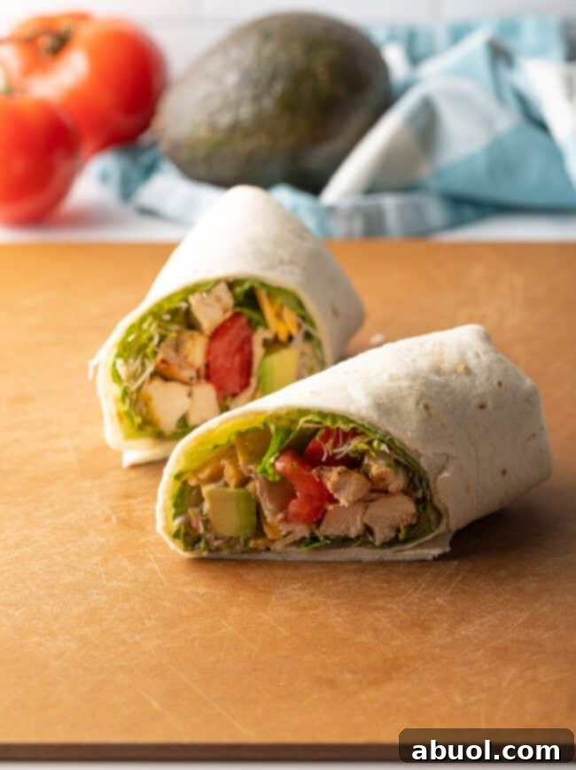 Two halves of a grilled chicken wrap lying one in front of the other.