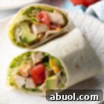 Top down view loaded chicken wrap, two pieces of the wrap are lying criss cross on each other.