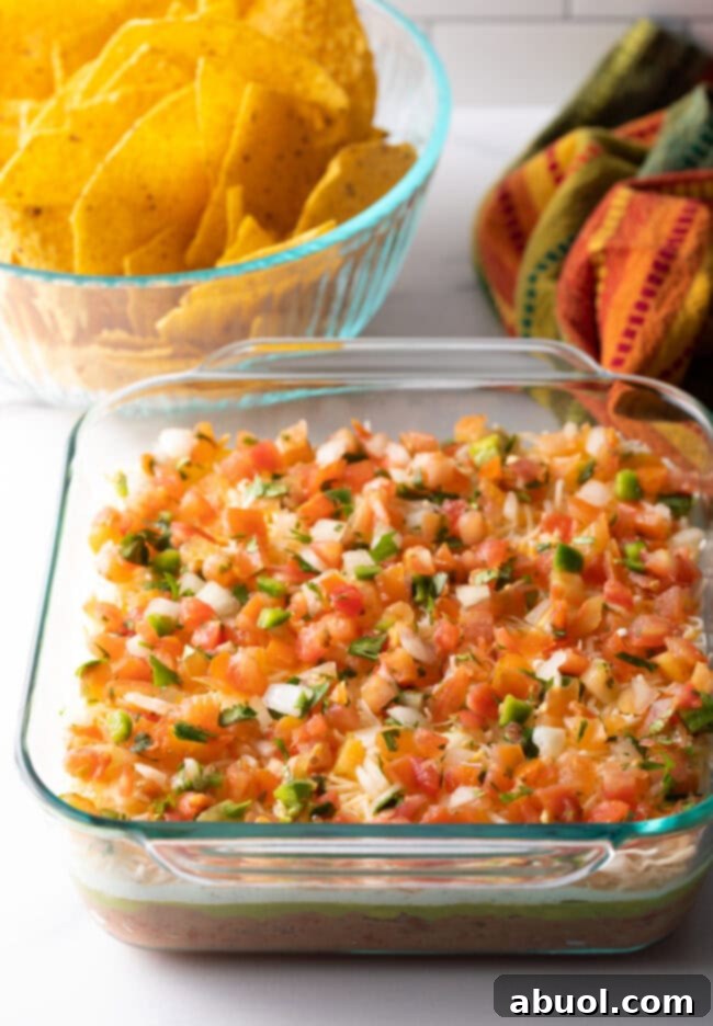 Glass square baking dish with layered dip.