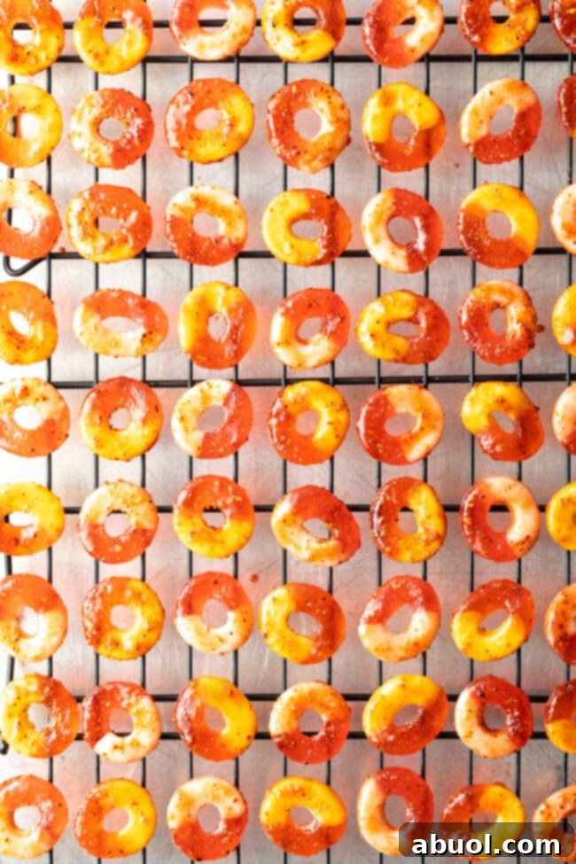 Chamoy and Tajin coated gummy candy rings. Dozens laid out in rows on metal drying racks.