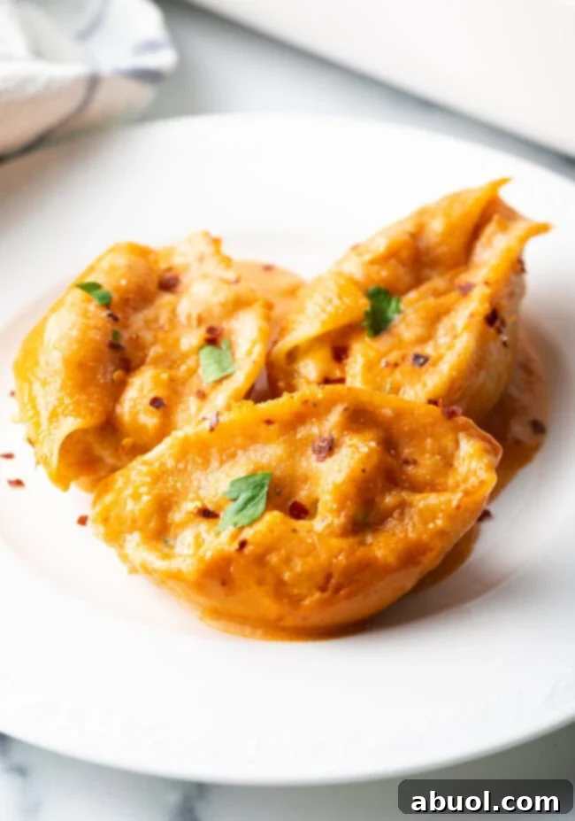 Serving of cheesy seafood pasta on a white plate, highlighting the rich sauce and filling.