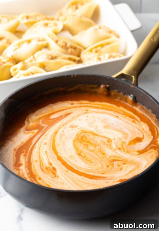 A vibrant, cheesy pasta sauce simmering gently in a skillet.