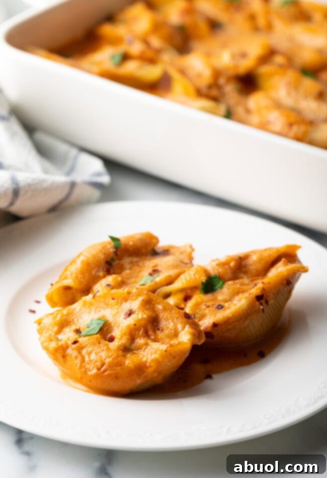 A second serving of cheesy seafood pasta on a white plate, showcasing its inviting appearance.