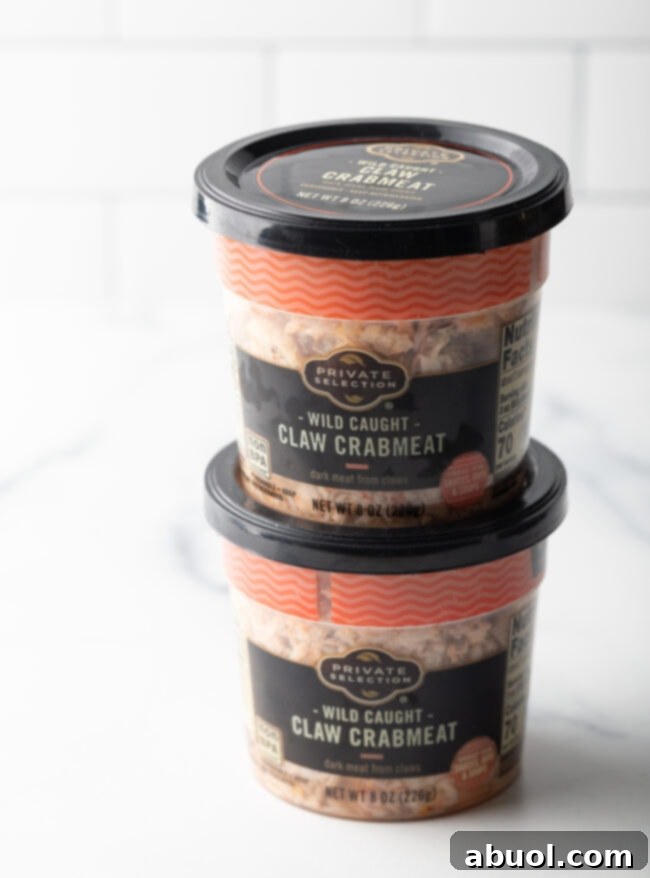 Two containers of fresh crab claw meat, showing its texture and color.