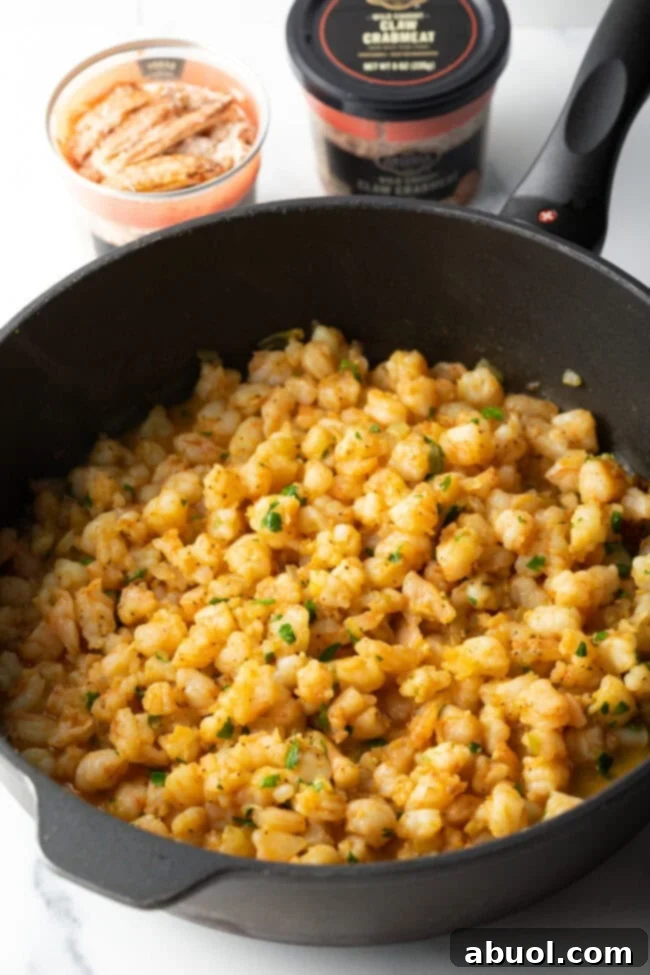 Cooked shrimp and crab in a skillet, gently mixed with melted butter and aromatics.