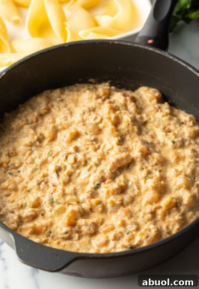 Seafood meat and cheese mixture in a saucepan, showing its creamy texture.