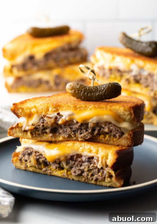 A freshly made patty melt, cut in half and ready to eat, with a golden brown crust.