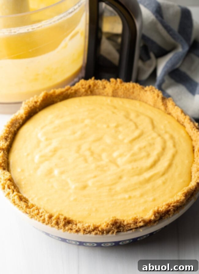Mango curd filling poured into graham cracker crust.