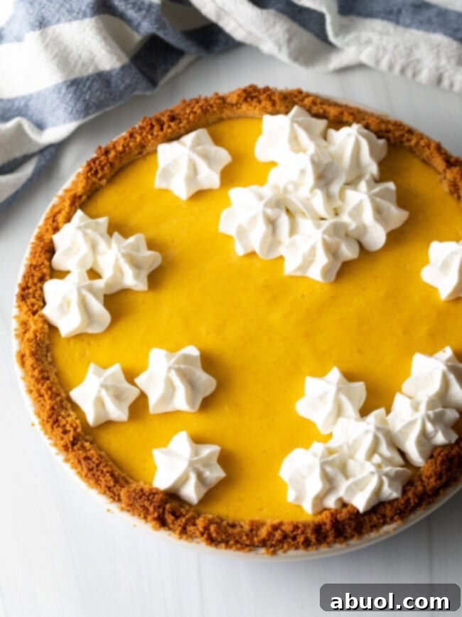 Whole baked mango pie with piping of whipped meringue in clusters on top.