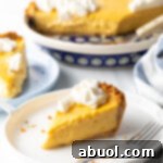 Slices of mango tart on a white plate, metal fork to the side.
