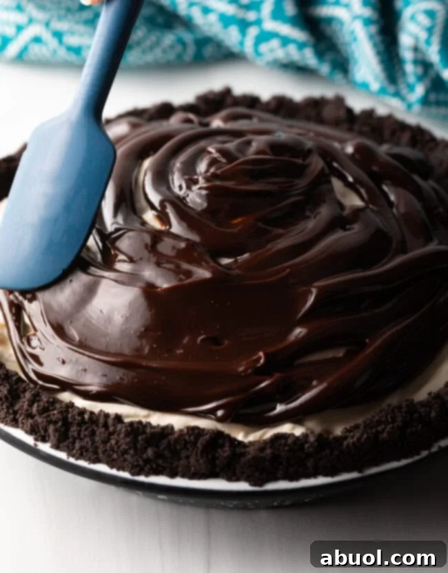 A beautifully decorated Duke's Hula Pie with whipped cream piped around the edges and a final sprinkle of chopped macadamia nuts.