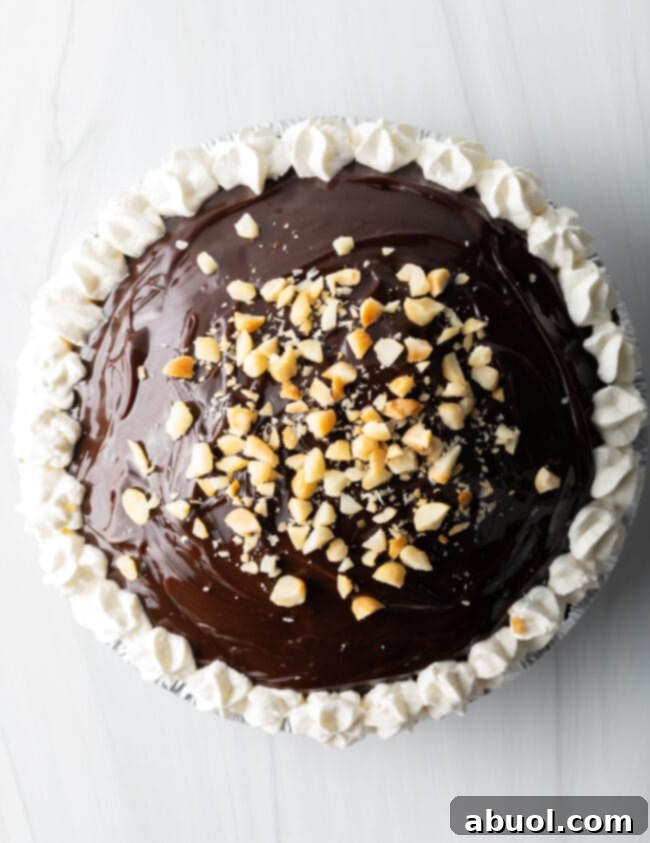 Top-down view of Duke's Hula Pie, elegantly piped with swirls of whipped cream and generously topped with chopped roasted macadamia nuts.