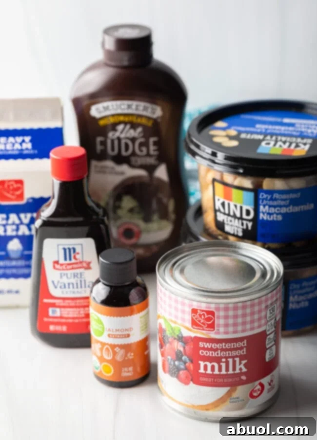 Recipe ingredients laid out: canned sweetened condensed milk, jars of hot fudge sauce, containers of macadamia nuts, bottles of almond extract and vanilla extract.