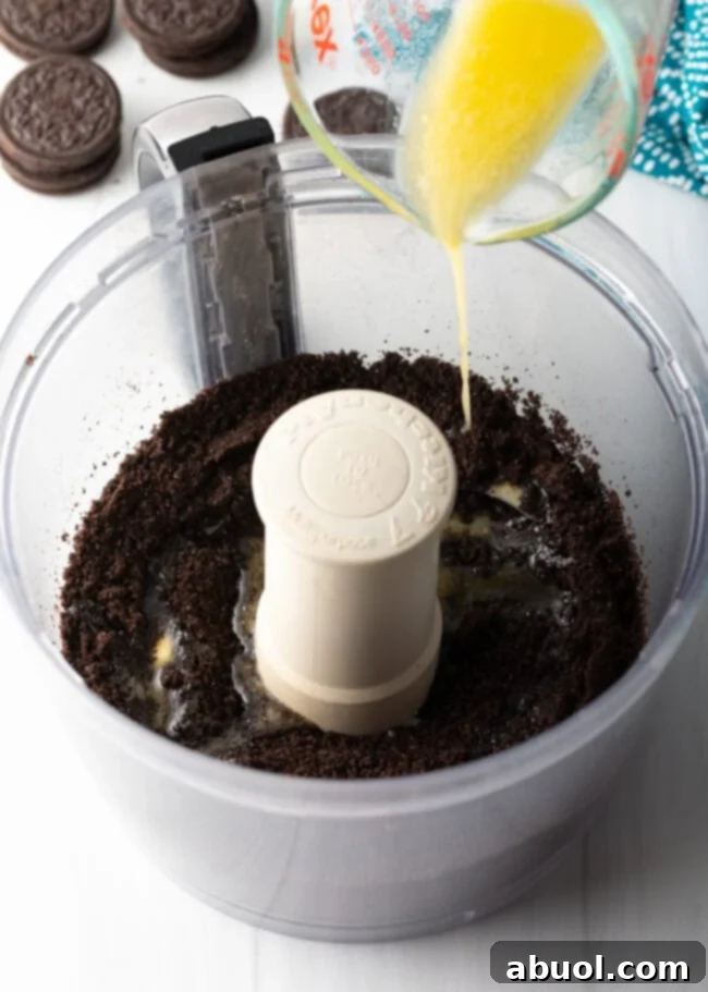 A bowl of finely crushed Oreo cookie crumbs, ready to be mixed with butter for the crust.