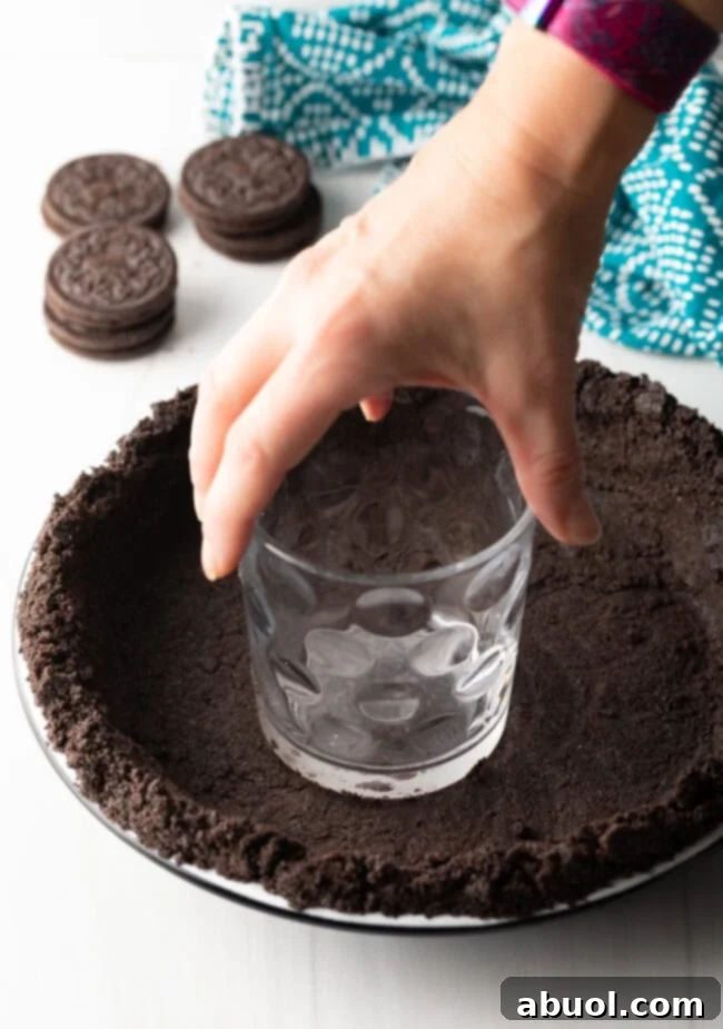Melted butter being poured over Oreo cookie crumbs in a mixing bowl.