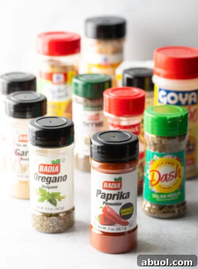 A colorful lineup of various spice bottles, including paprika, oregano, and lemon pepper, essential for homemade blends.