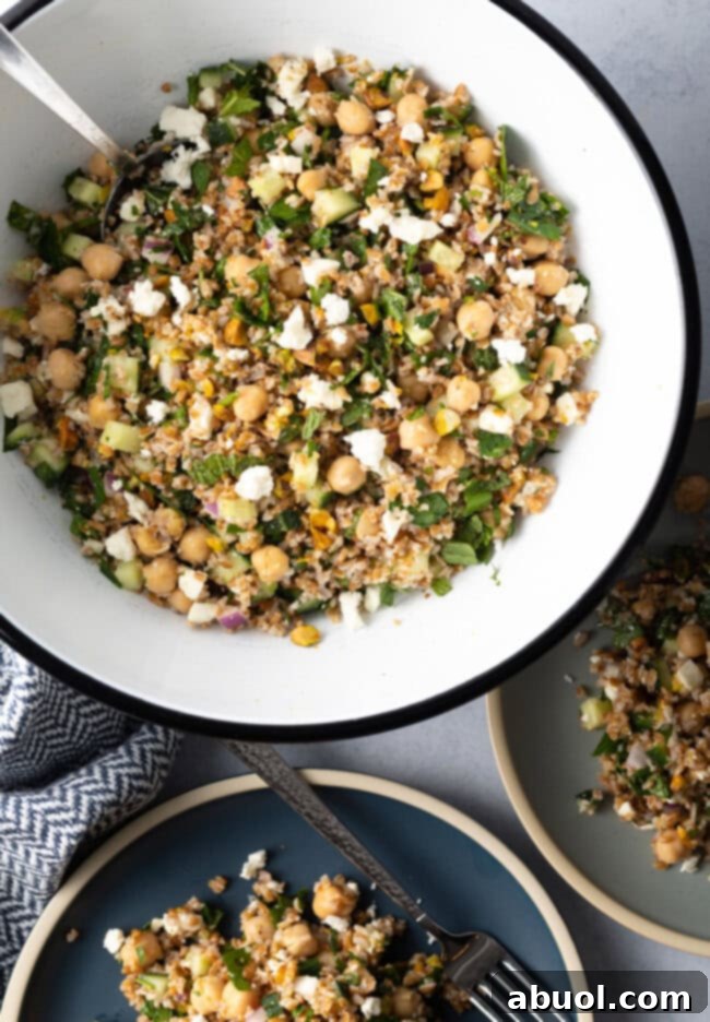 Large white bowl filled with bulgar wheat, veggies, and feta salad.