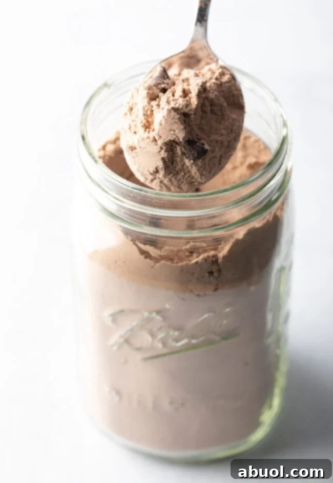 Another perspective of dry ingredients being artfully layered into a mason jar, emphasizing the aesthetic for gift-giving and showcasing the distinct ingredient layers.