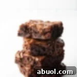A stack of four perfectly baked Ghirardelli brownies, showcasing their rich texture and delicious appearance.