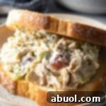 Large turkey salad sandwich on a white plate.