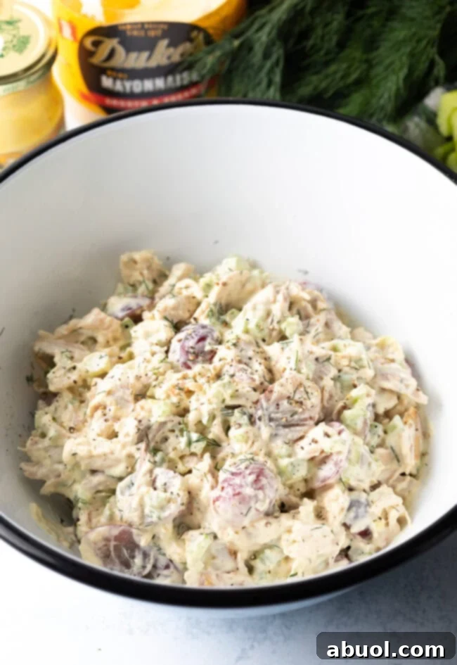 All ingredients for leftover turkey salad combined in white bowl.