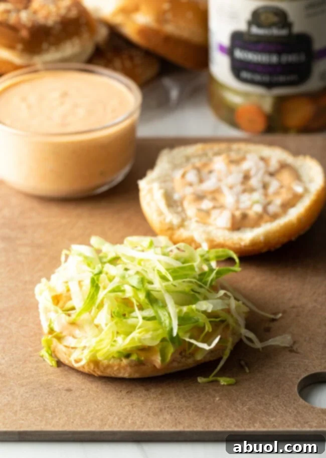 Two halves of hamburger buns. One is topped with shredded lettuce and the other one is topped with Big Mac sauce.