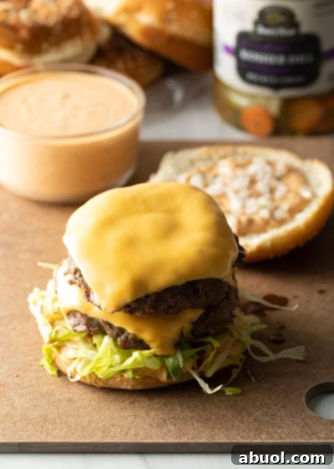 Cheeseburger patty on a bun with shredded lettuce.