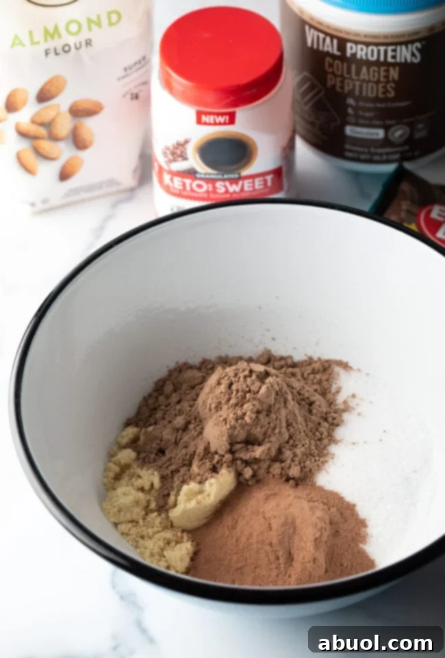 Power & Glow Collagen Brownies 6 Dry ingredients like cocoa powder, collagen, sweetener, and almond flour in a white mixing bowl.