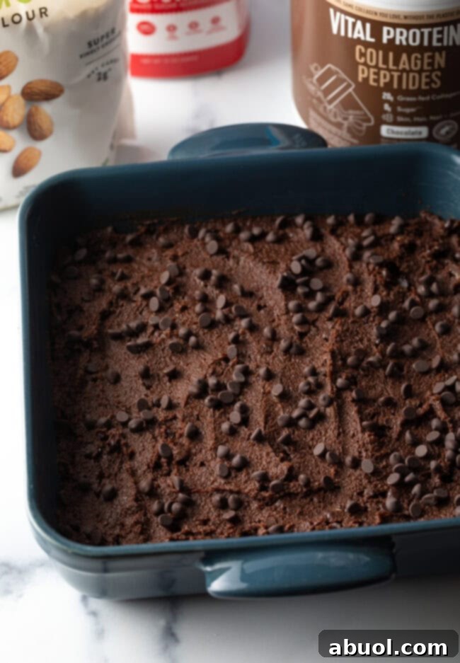 Power & Glow Collagen Brownies 8 Thick brownie batter spread evenly into a square baking pan, ready for the oven.
