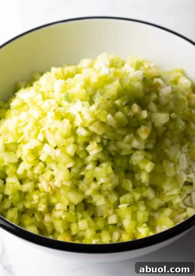 Adding chopped tomatillos to the bowl.