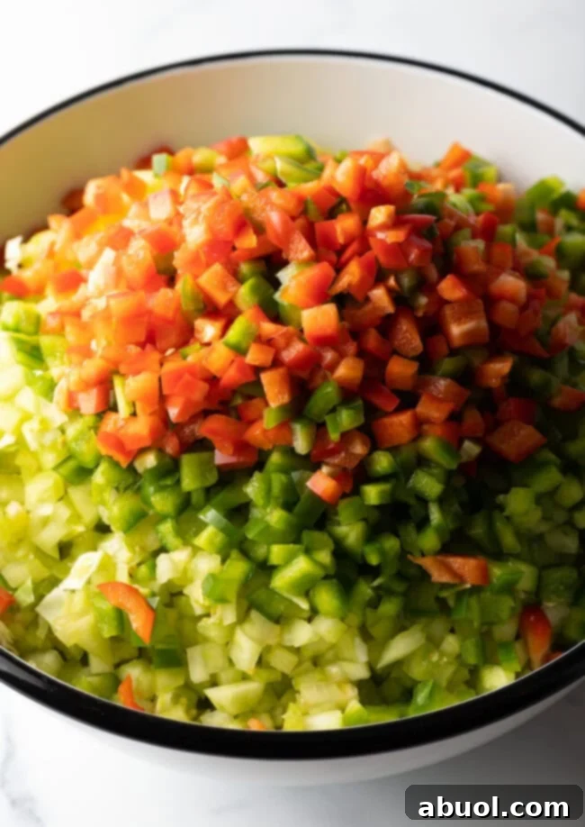 Adding chopped bell pepper to the bowl of veggies.