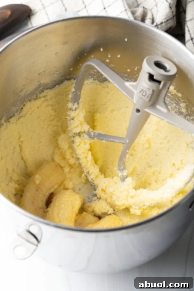 Metal bowl with batter, mixing paddle in the bowl.