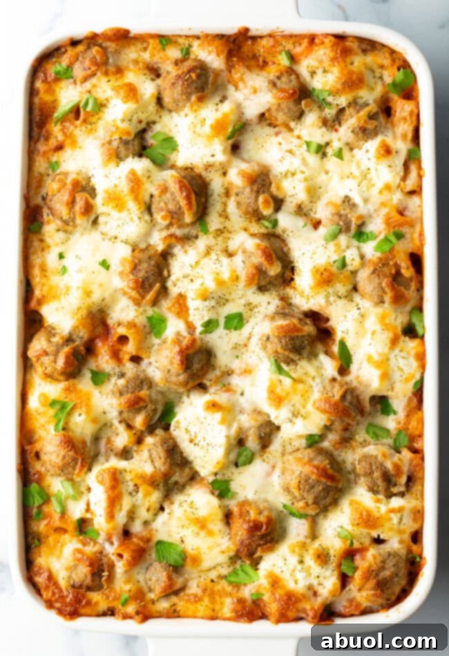 Baked meatball casserole in a white dish, bubbly cheese on top.