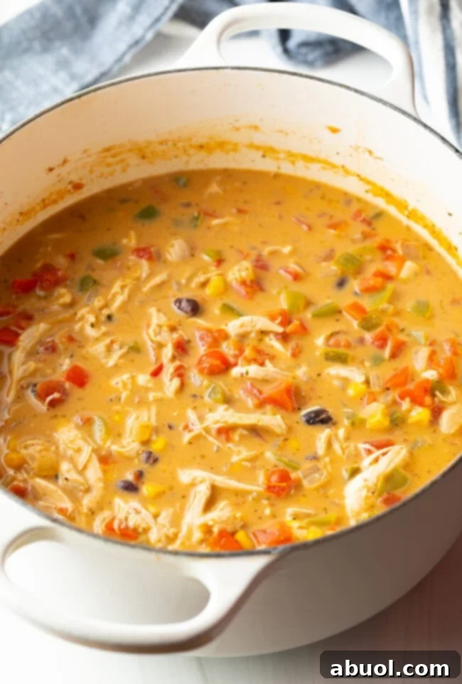 Another perspective of the creamy chicken, bean, and corn soup cooking in a white pot, showing its rich texture.