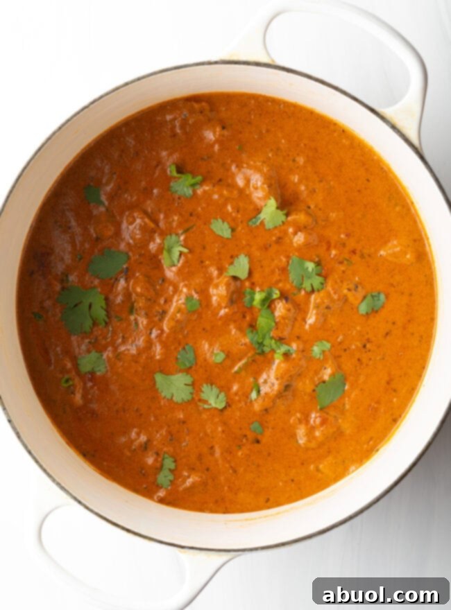 Creamy Lamb Tikka Masala 15 Top down tomato lamb curry sauce in a white cooking pot.