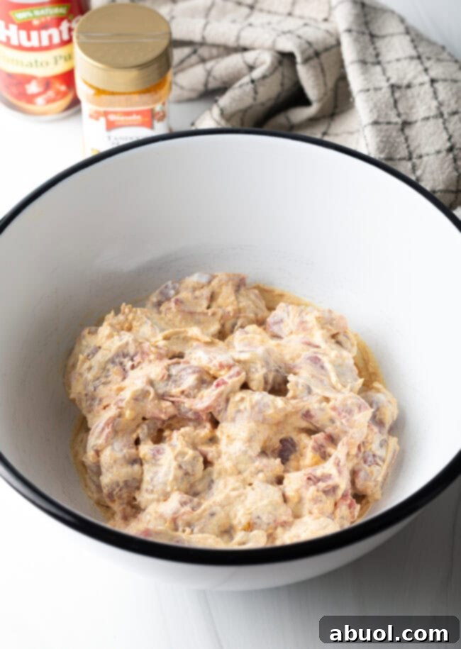 Creamy Lamb Tikka Masala 7 Yogurt marinated lamb pieces in a white mixing bowl.