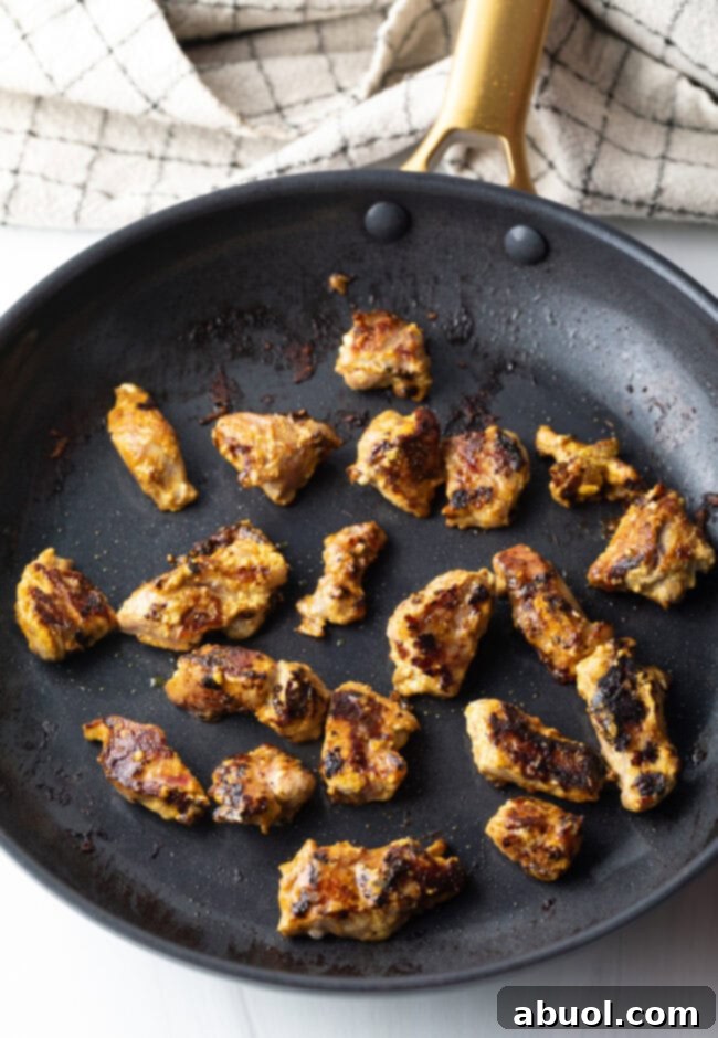 Creamy Lamb Tikka Masala 10 Pieces of lamb meat searing in a cast iron skillet.