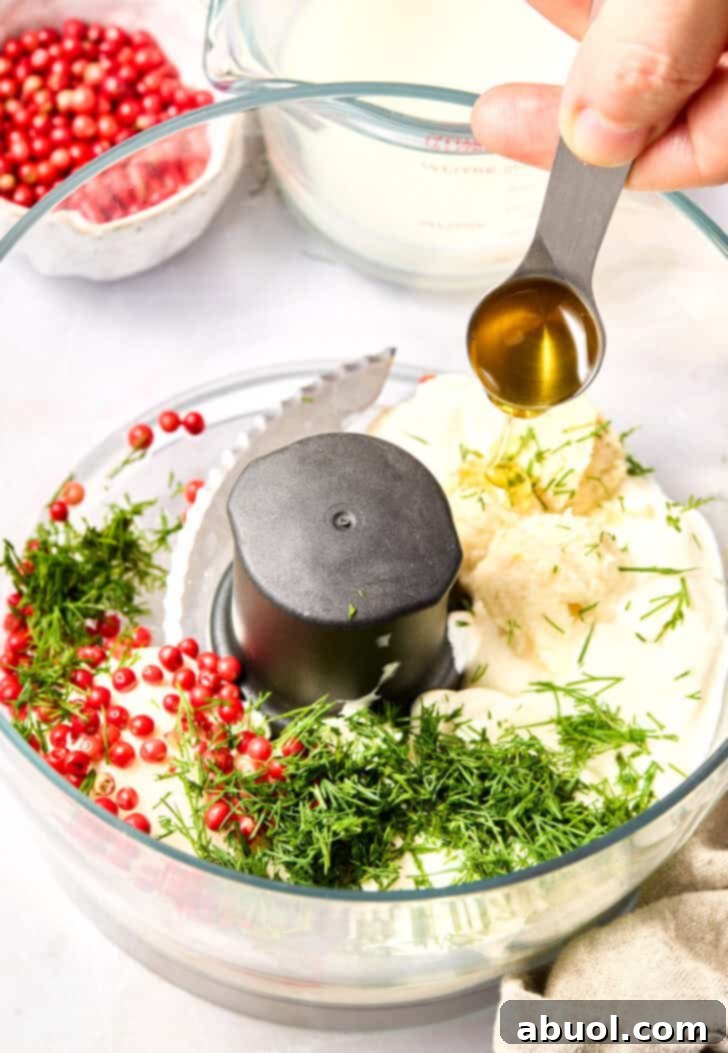 Adding fresh dill and peppercorns to sauce in food processor