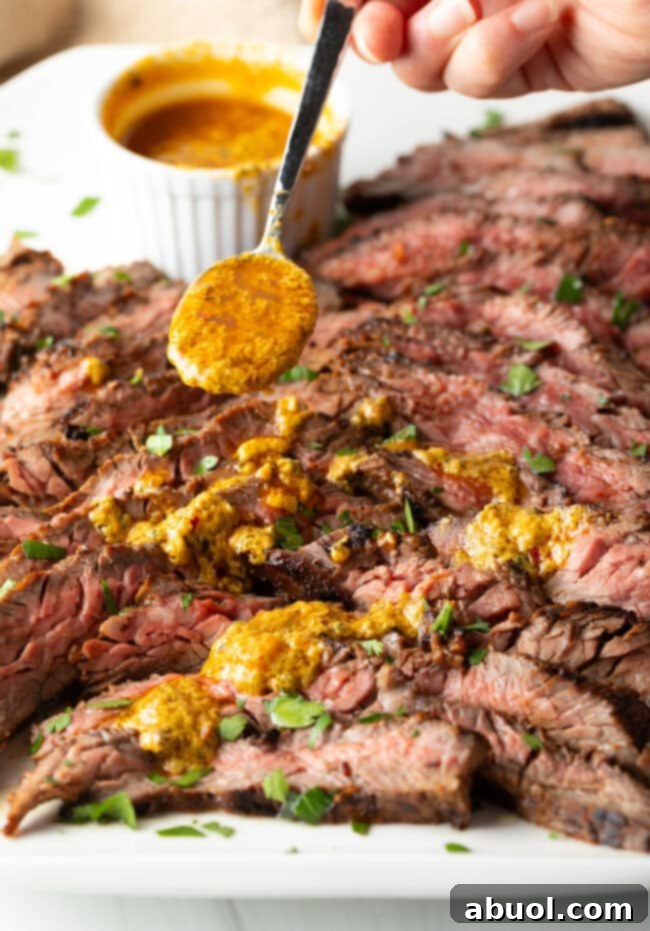 Spooning melted spiced butter over slices of tender steak.