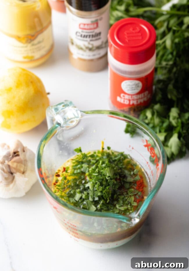 Adding chopped fresh herbs to a glass measuring pitcher.