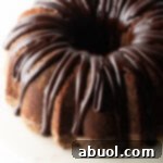 Top down view, circular chocolate sour cream bundt cake with a thick chocolate glaze drizzled on top.