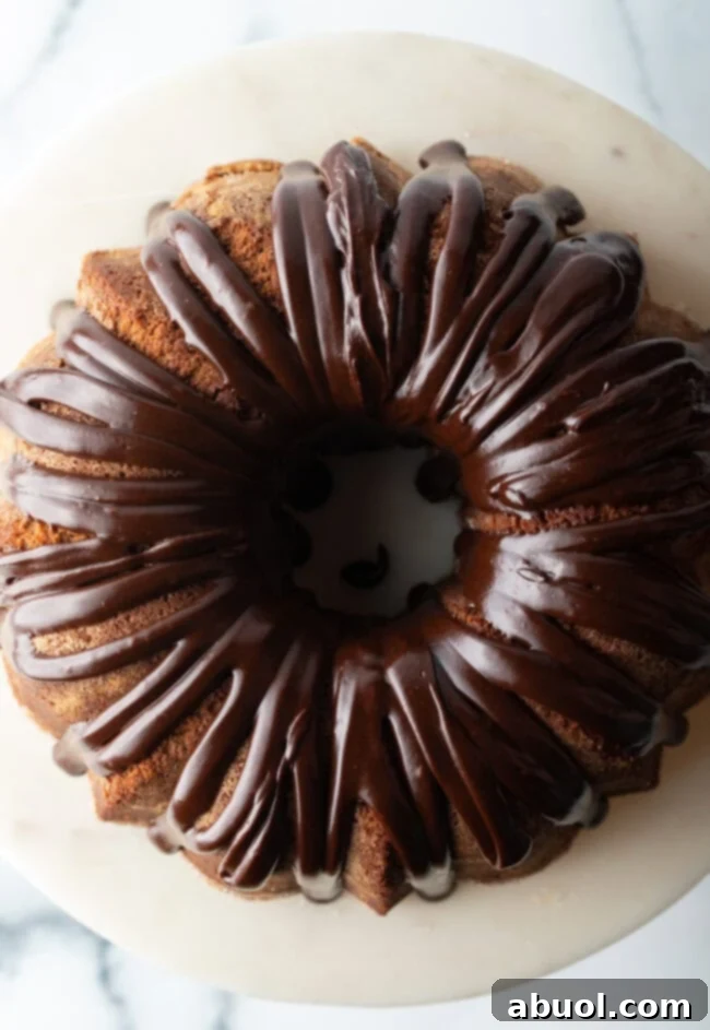 Top down view, circular chocolate sour cream bundt cake with a thick chocolate glaze drizzled on top.