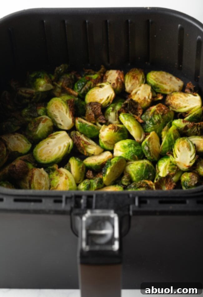 Brussels sprouts halves in an air fryer basket.