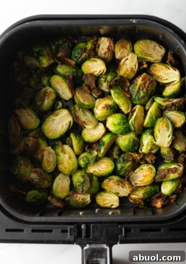 Top down crispy Brussels sprouts halves in an air fryer basket.