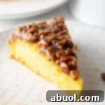 Single slice of upside down pecan cake on a white plate.