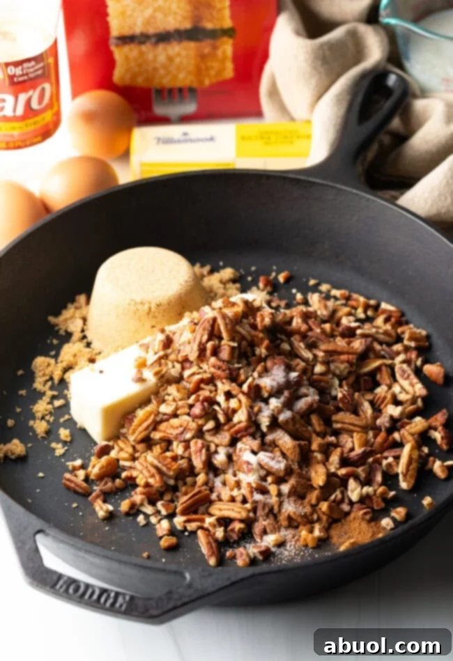 Raw ingredients for the pecan topping, including chopped nuts, brown sugar, butter, and cinnamon, gathered in a cast iron skillet.