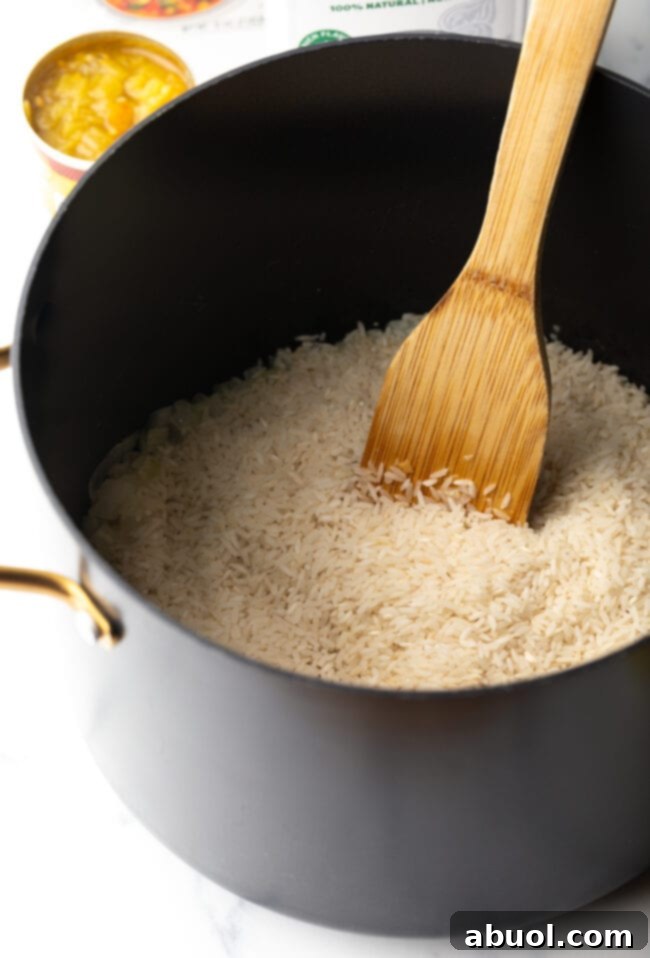 White rice in a pot with wooden spoon.