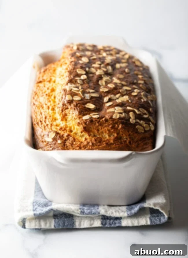 Full loaf of cottage cheese bread with oats in a white loaf pan.